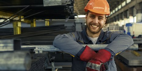 Ein Bauhelfer der einen Bauhelm trägt