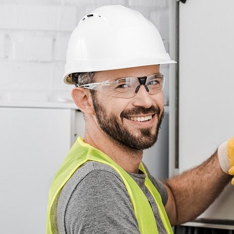 Ein Mann der eine Schutzbrille und einen Bauhelm trägt